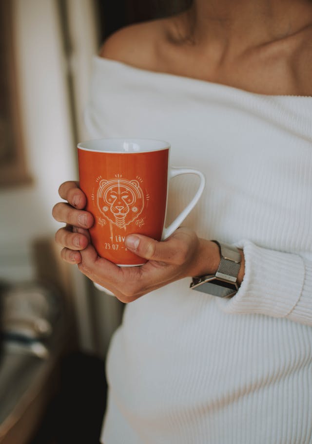 woman holding a zodiac sign cup before entering her office