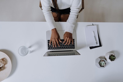 woman sitting at a computer writing blog content for a ecommerce brand