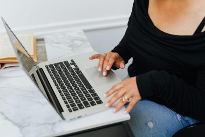 woman sitting at a computer writing a welcome email sequence for a ecomemrce brand